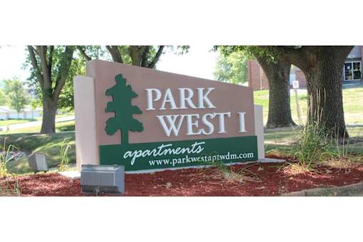 A sign for Park West 1 apartments is shown in front of a tree.