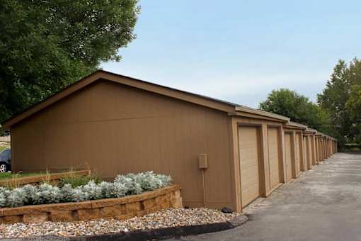 A long row of brown garages with doors closed.