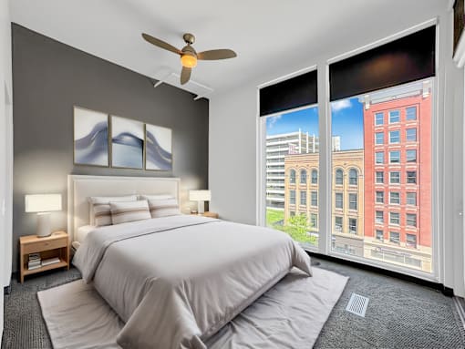 A bedroom with a large bed and a ceiling fan.