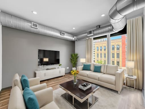 A modern living room with a white sofa, a coffee table, and a television.