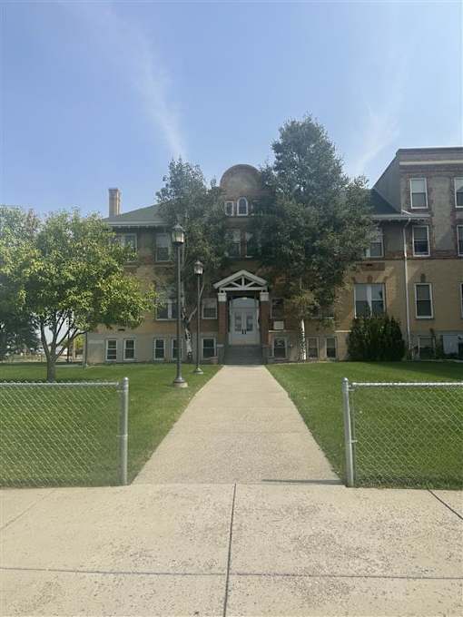 The Cornerstone Apartments with a fence in front of it.