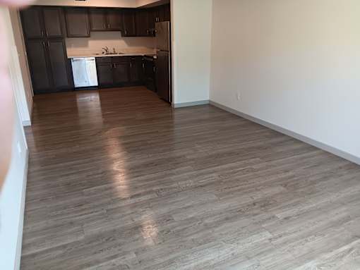 A kitchen with dark brown cabinets and a white dishwasher.