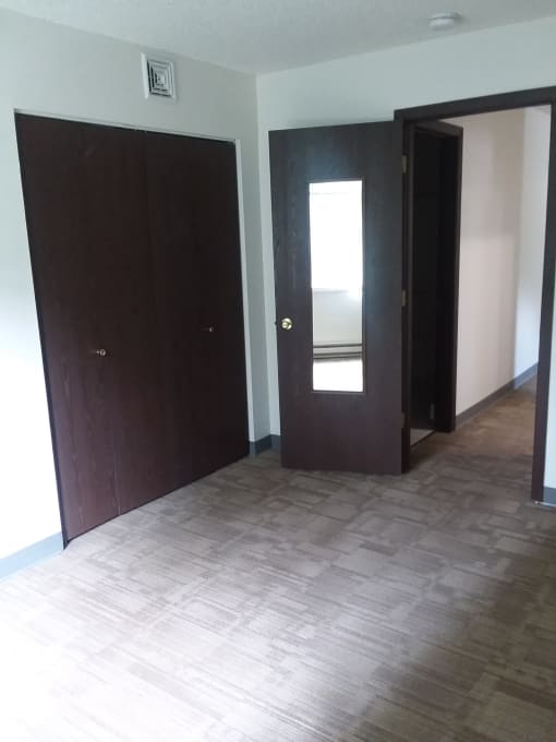 Image of bedroom with closet and carpeted floor