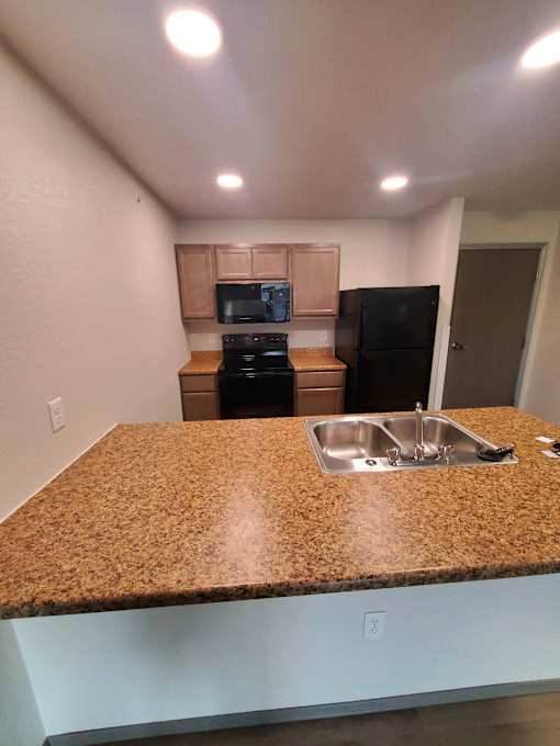 A kitchen with granite countertops and stainless steel appliances.