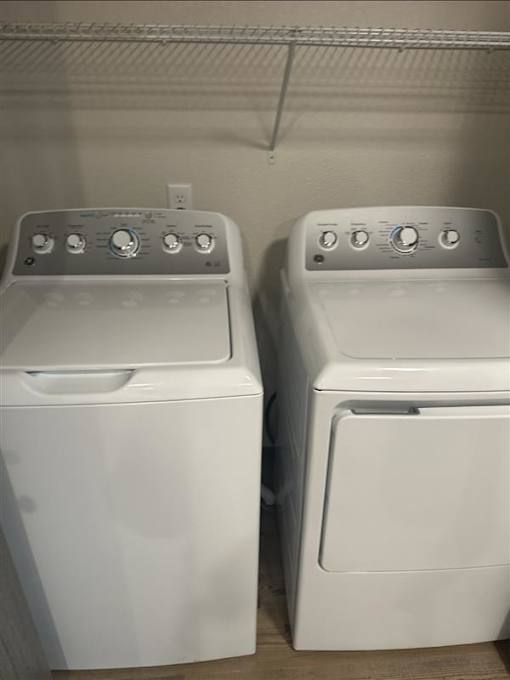 Two white front loading washing machines in a laundry room.