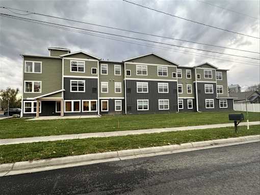 Apartment building with grey and white exterior on a cloudy day.