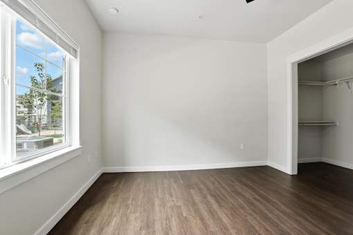 A room with a window and a wooden floor.