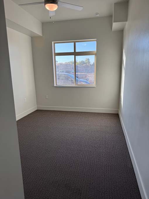 a bedroom with a closet and a bathroom in the background