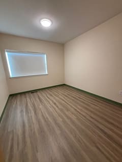 A room with wooden flooring and a window.