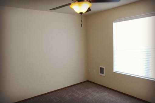 Space with window, fan, and wall heater