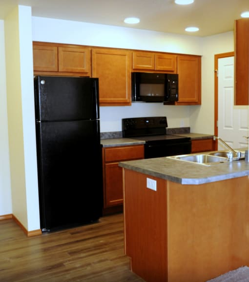 Image of refrigerator, sink, stove,  microwave, and cabinets