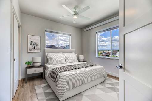 A bedroom with a bed, nightstand, and window.