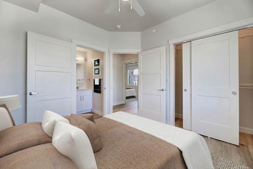 A bedroom with a bed and a ceiling fan.