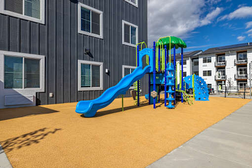 A playground with a blue slide and a green top.