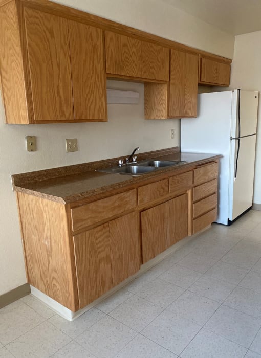 an empty kitchen with wooden cabinets and a sink