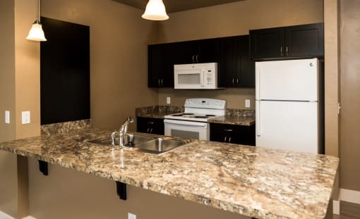 a kitchen with a granite counter top and white appliances