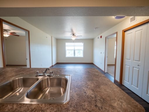 Image of living space with overhead fan and windows