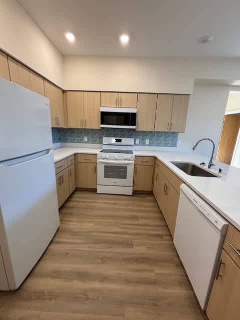 A kitchen with wooden cabinets and a white refrigerator.