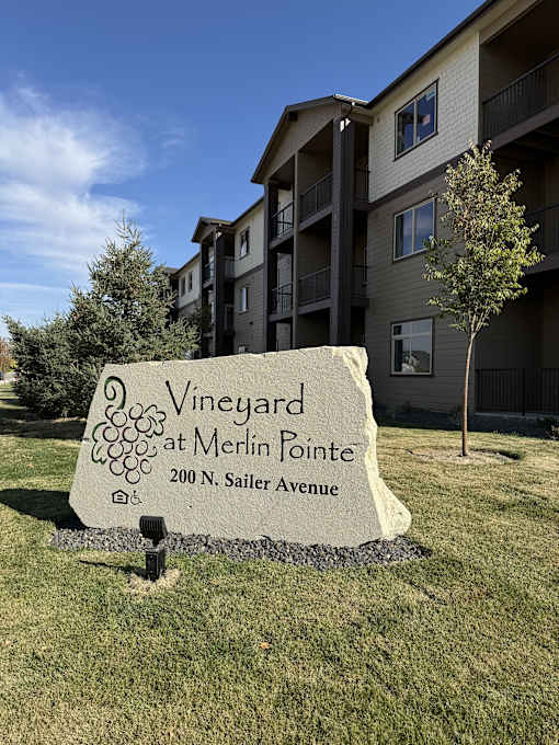 a sign for the vineyard at merrill pointe in front of an apartment