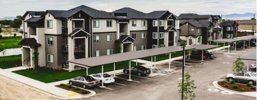an aerial view of an apartment building with cars parked in a parking lot