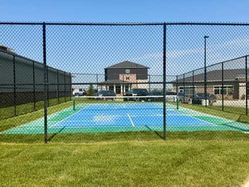 A blue and green pool surrounded by a black fence.