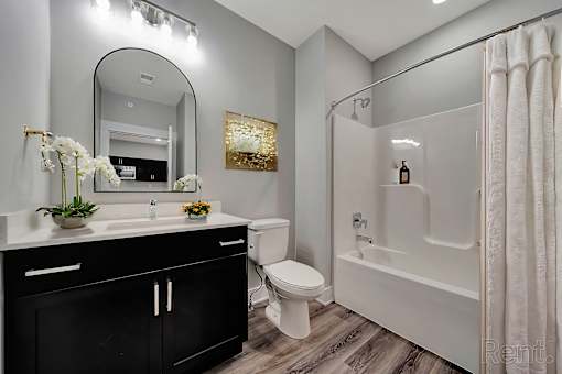 A bathroom with a sink, toilet, and bathtub.