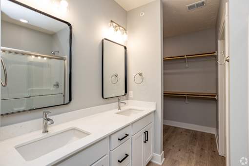 A bathroom with a white sink and a mirror above it.