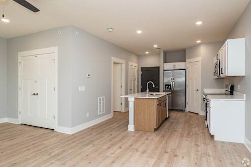 A kitchen with white cabinets and a wooden island.