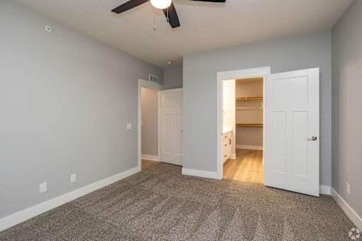 A room with a ceiling fan and a carpeted floor.