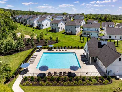 A swimming pool surrounded by a grassy area and a fence.