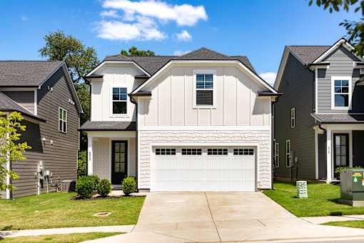 A white garage door is in the center of a driveway.