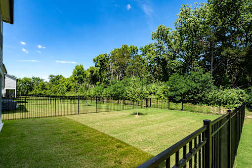 A black fence surrounds a green lawn.