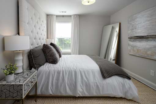 A bedroom with a large bed and a painting on the wall.