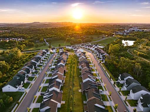 A sunset view of a residential neighborhood with houses and streets.