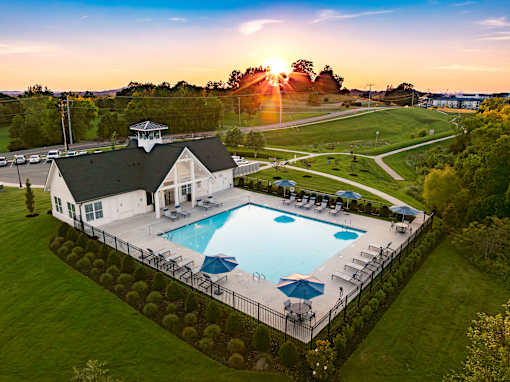 A beautiful sunset over a pool and a house.