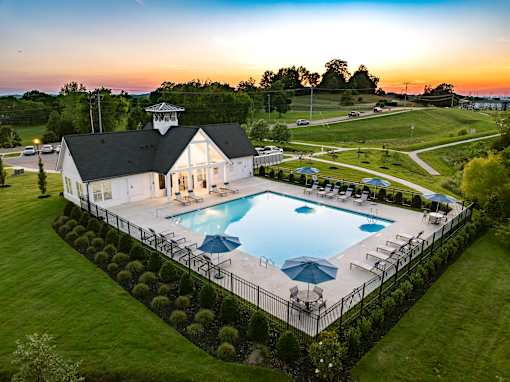 A pool with a white building and a black roof.