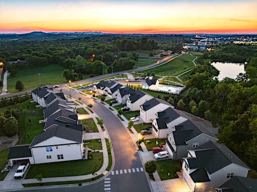 A sunset view of a residential neighborhood with houses and a golf course.