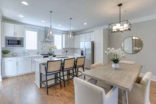 A modern kitchen with a dining table and chairs.