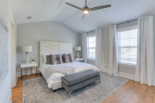 A bedroom with a large bed and a ceiling fan.