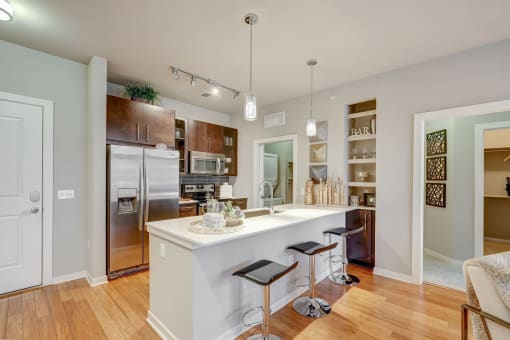 Kitchen with island, white quartz counters and dark cabinets