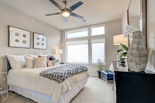 A bedroom with a large bed and a ceiling fan.