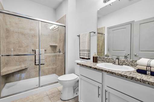 A bathroom with a toilet, sink, and shower.