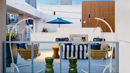 A patio with a table and chairs and a blue umbrella.