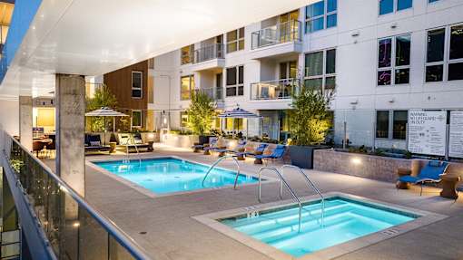 A swimming pool area with a slide and lounging chairs.