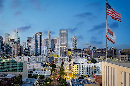 A cityscape with a flag flying in the foreground.