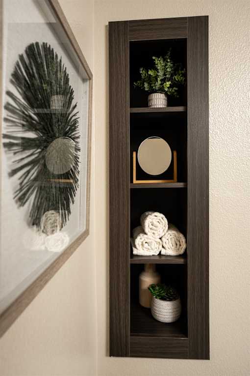 A brown shelf with a mirror and a plant on it.