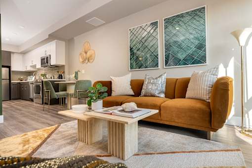 A living room with a brown couch and a coffee table in the middle.