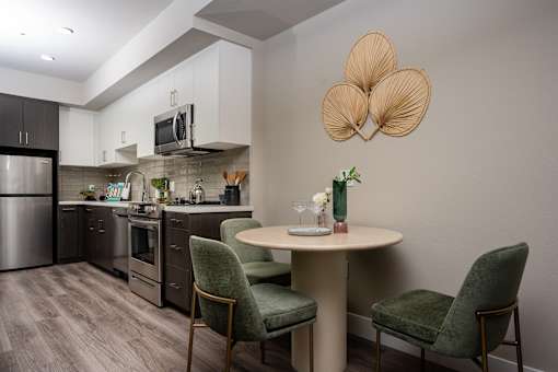 A modern kitchen with a dining table set for two.