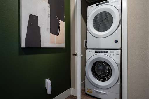 A white front loading washing machine in a laundry room.
