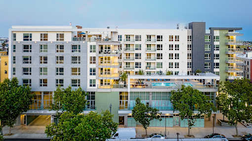 A modern multi-story building with a pool in the middle.